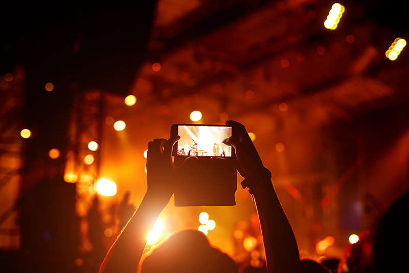 Fan taking photo of concert at festival