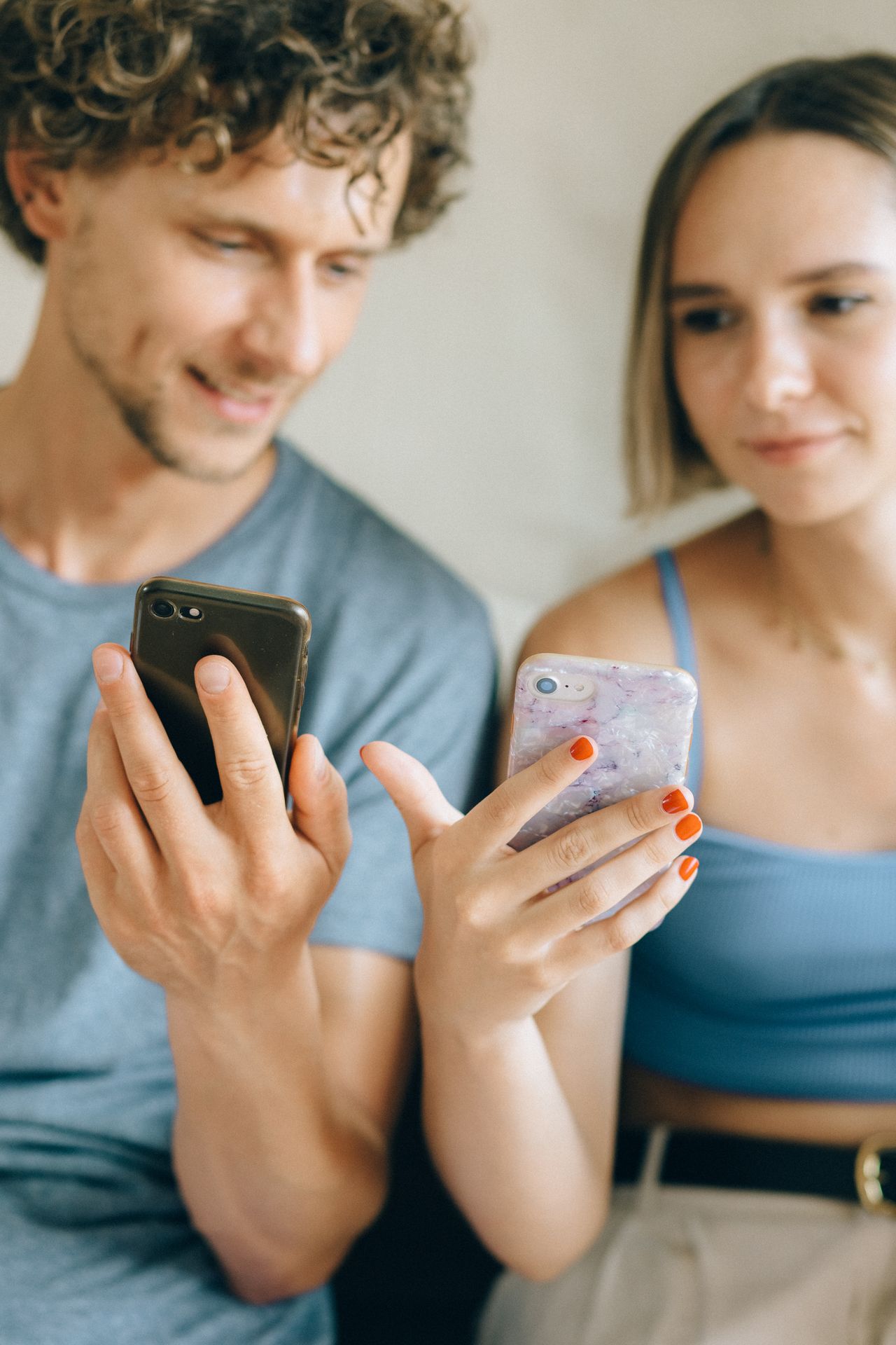 Telefónica y Hiya permitirán identificar a las empresas que llaman al móvil sin instalar aplicaciones a close-up of a young couple sitting indoors, using smartphones together.