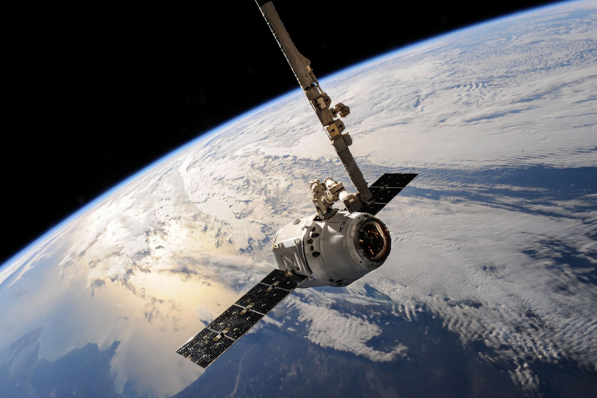 a satellite glides over earth showcasing dramatic cloud formations and the vast expanse of space.