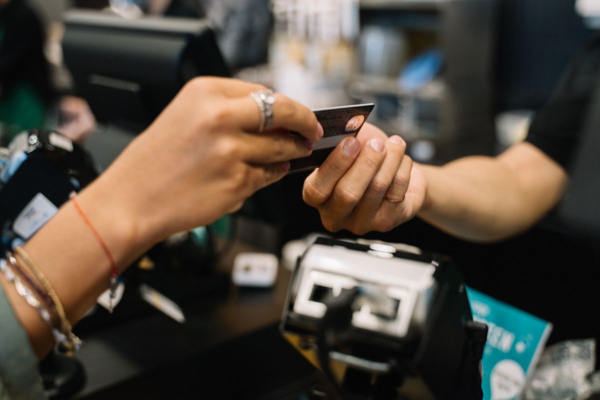 El TJUE obliga a los bancos a devolver los pagos no autorizados aunque exista negligencia grave del cliente close-up of hands completing a payment transaction at a retail checkout using a bank card.