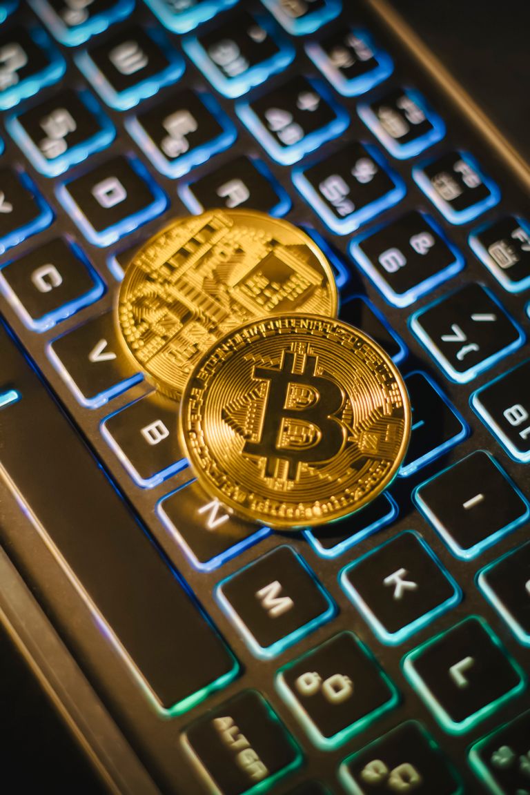 La ESMA exige dejar de ofrecer servicios con stablecoins que incumplan MiCA two bitcoin coins resting on an illuminated keyboard, showing cryptocurrency and digital finance themes.
